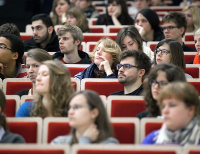 Foto: Studierende sitzen im Hörsaal und hören aufmerksam zu